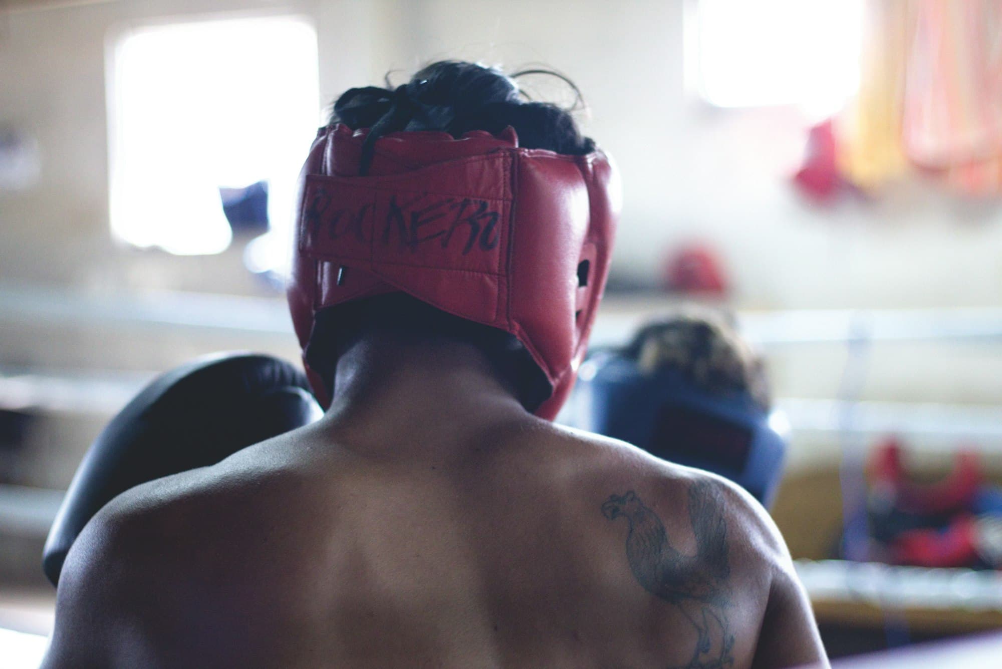 A boxer in headgear, listening to the corner